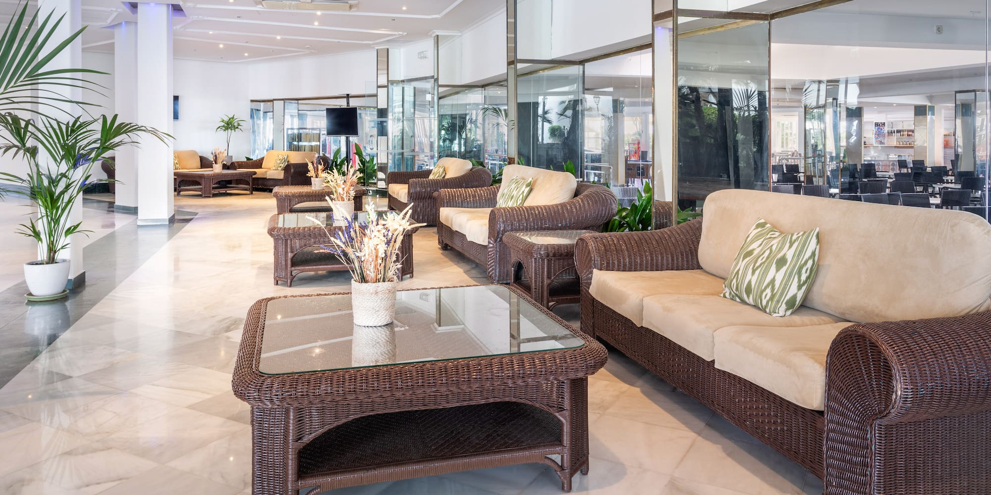 a room with wicker furniture and a glass table