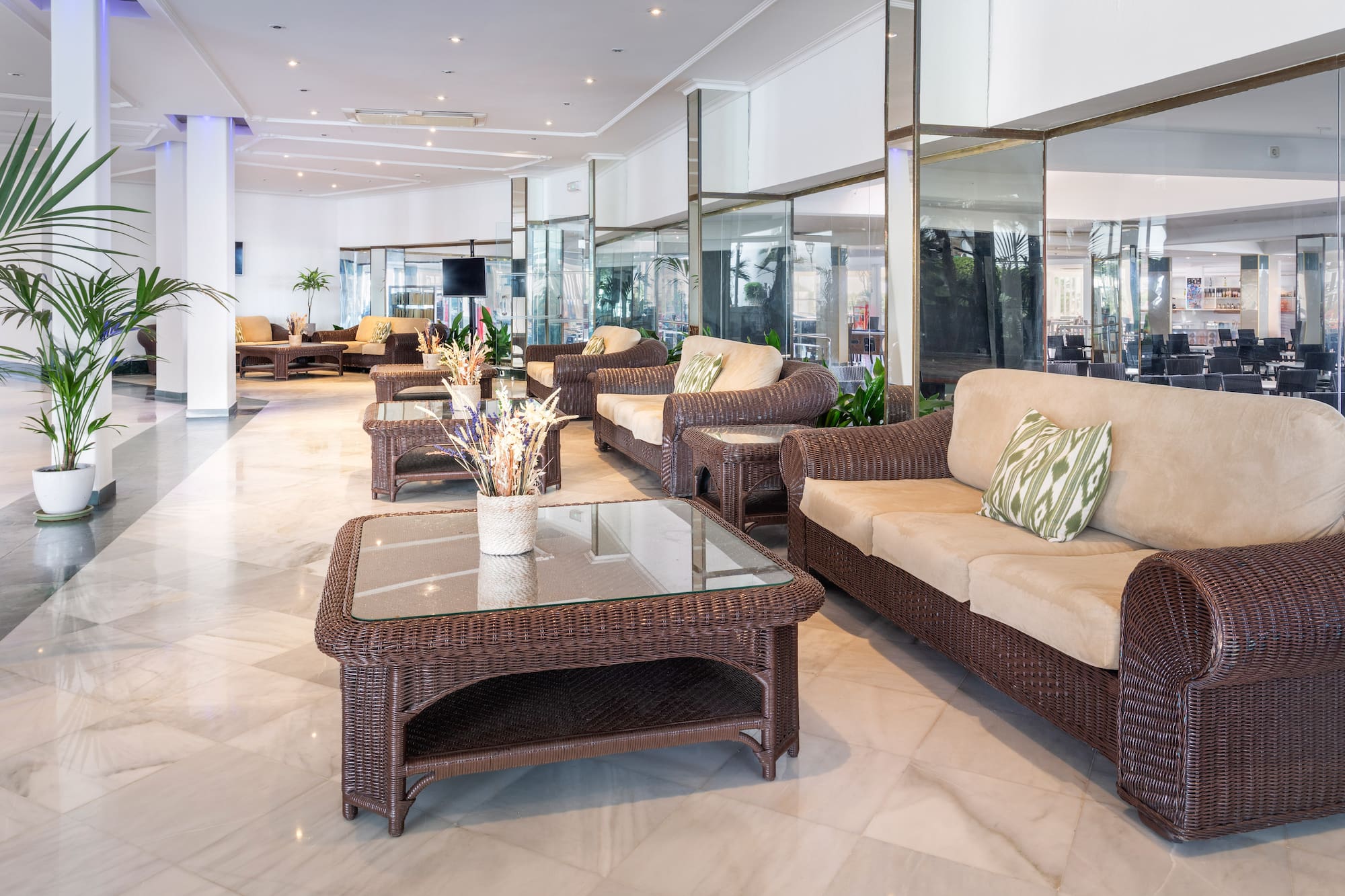 a room with wicker furniture and a glass table