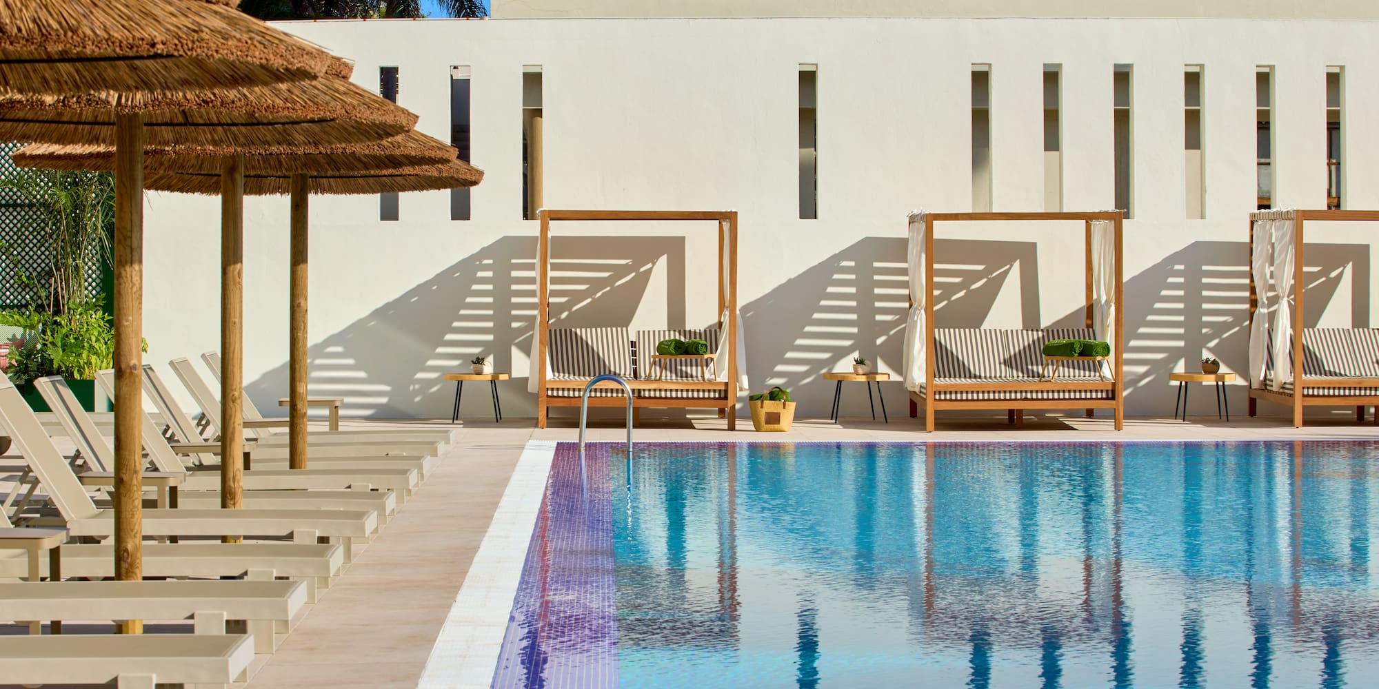 a pool with lounge chairs and umbrellas