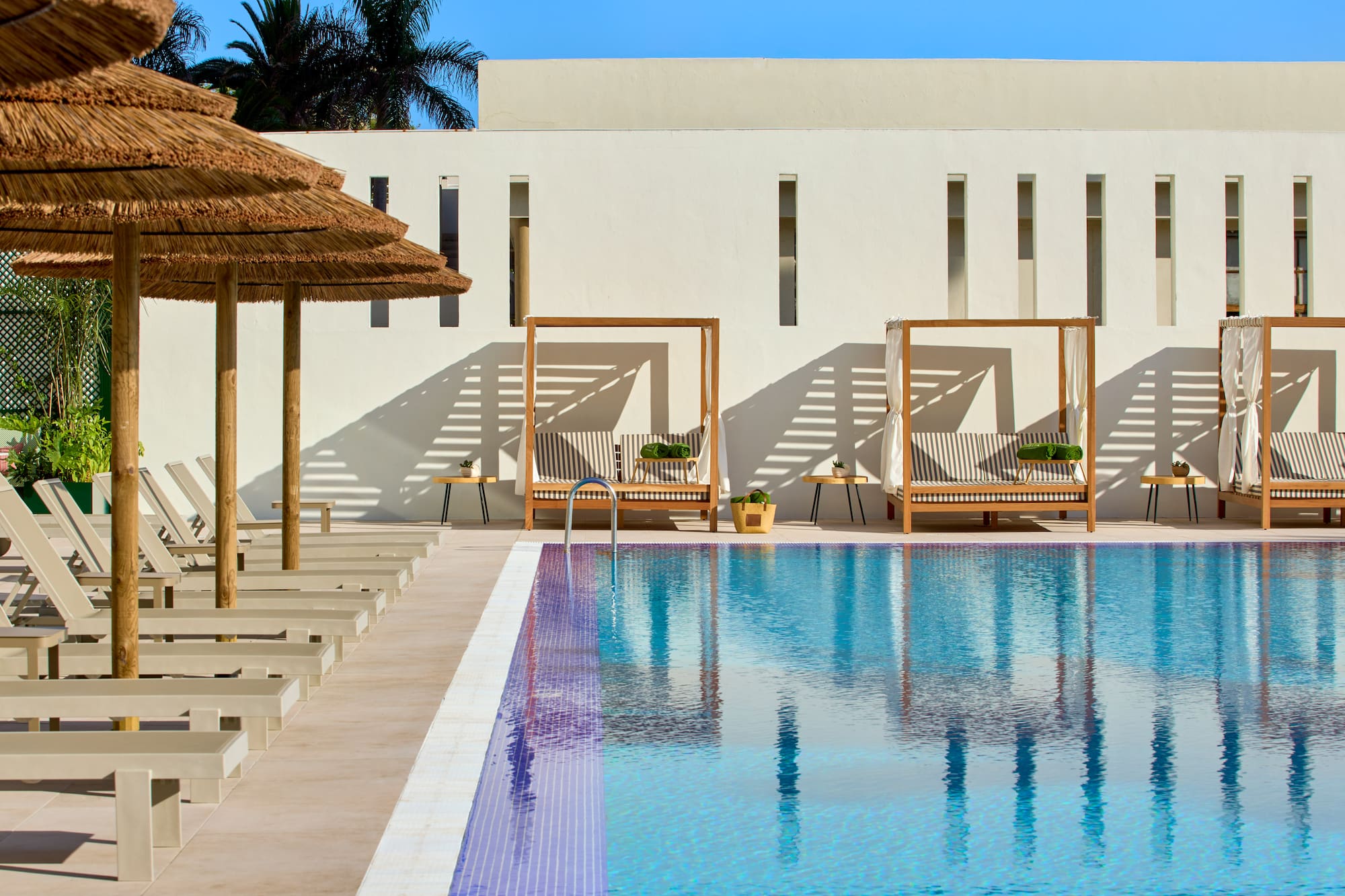 a pool with lounge chairs and umbrellas