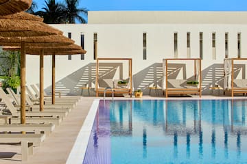 a pool with lounge chairs and umbrellas