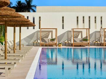 a pool with lounge chairs and umbrellas