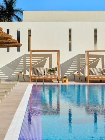 a pool with lounge chairs and umbrellas