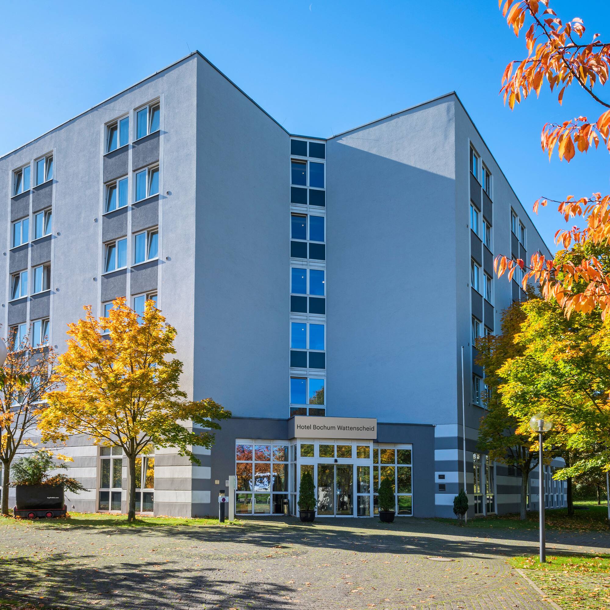 a building with trees and a driveway