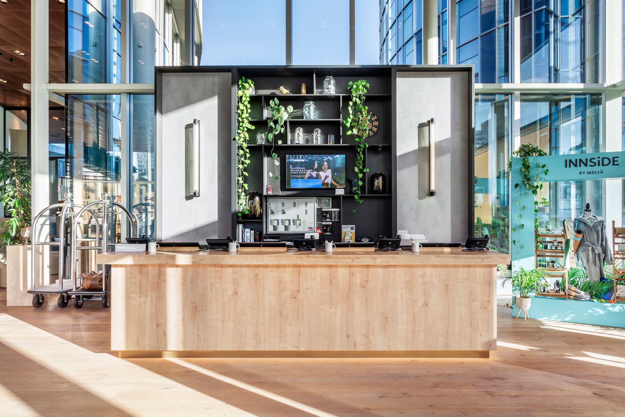 INNSiDE by Meliá hotel reception desk, modern lobby with plants & bright windows.