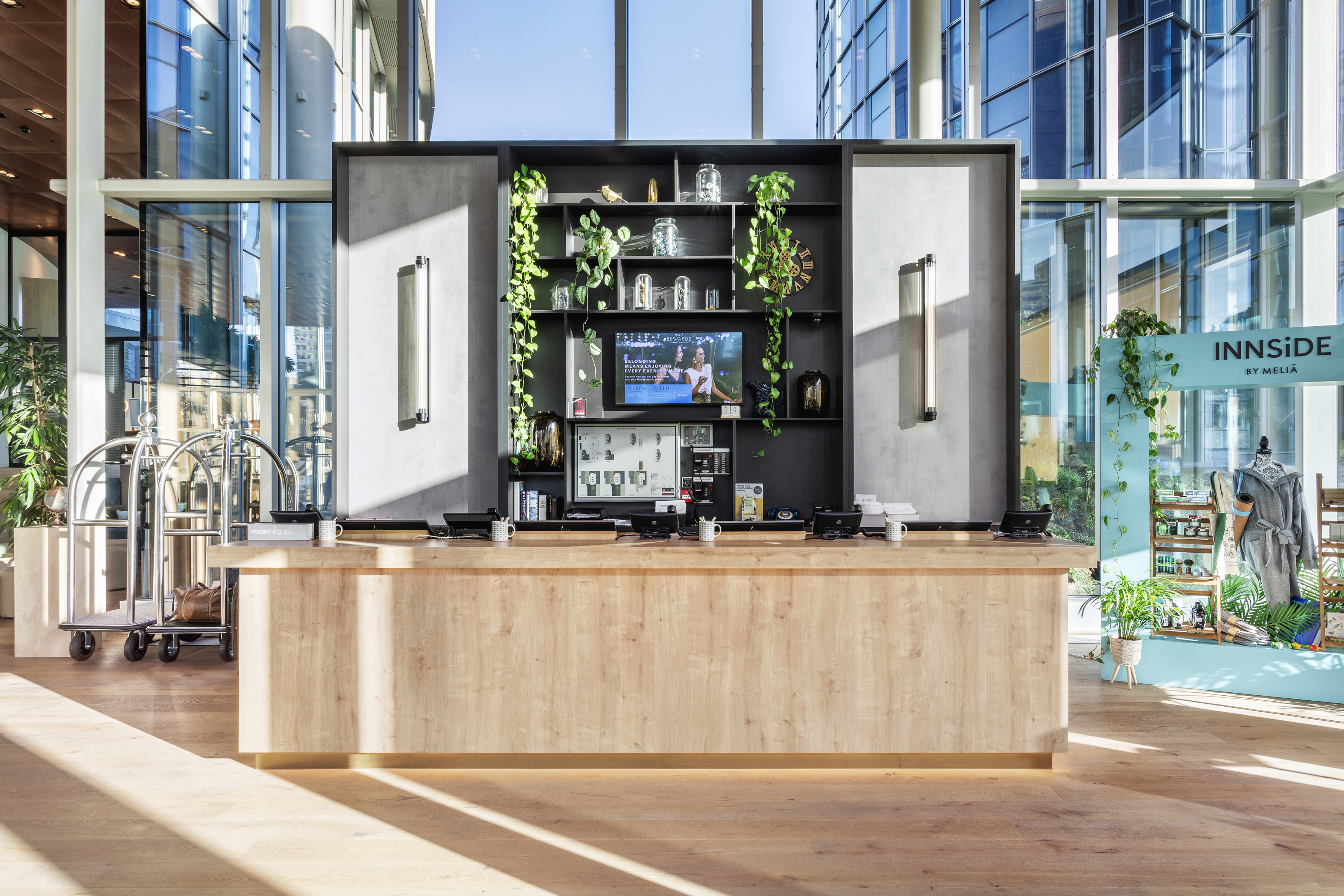 INNSiDE by Meliá hotel reception desk, modern lobby with plants & bright windows.