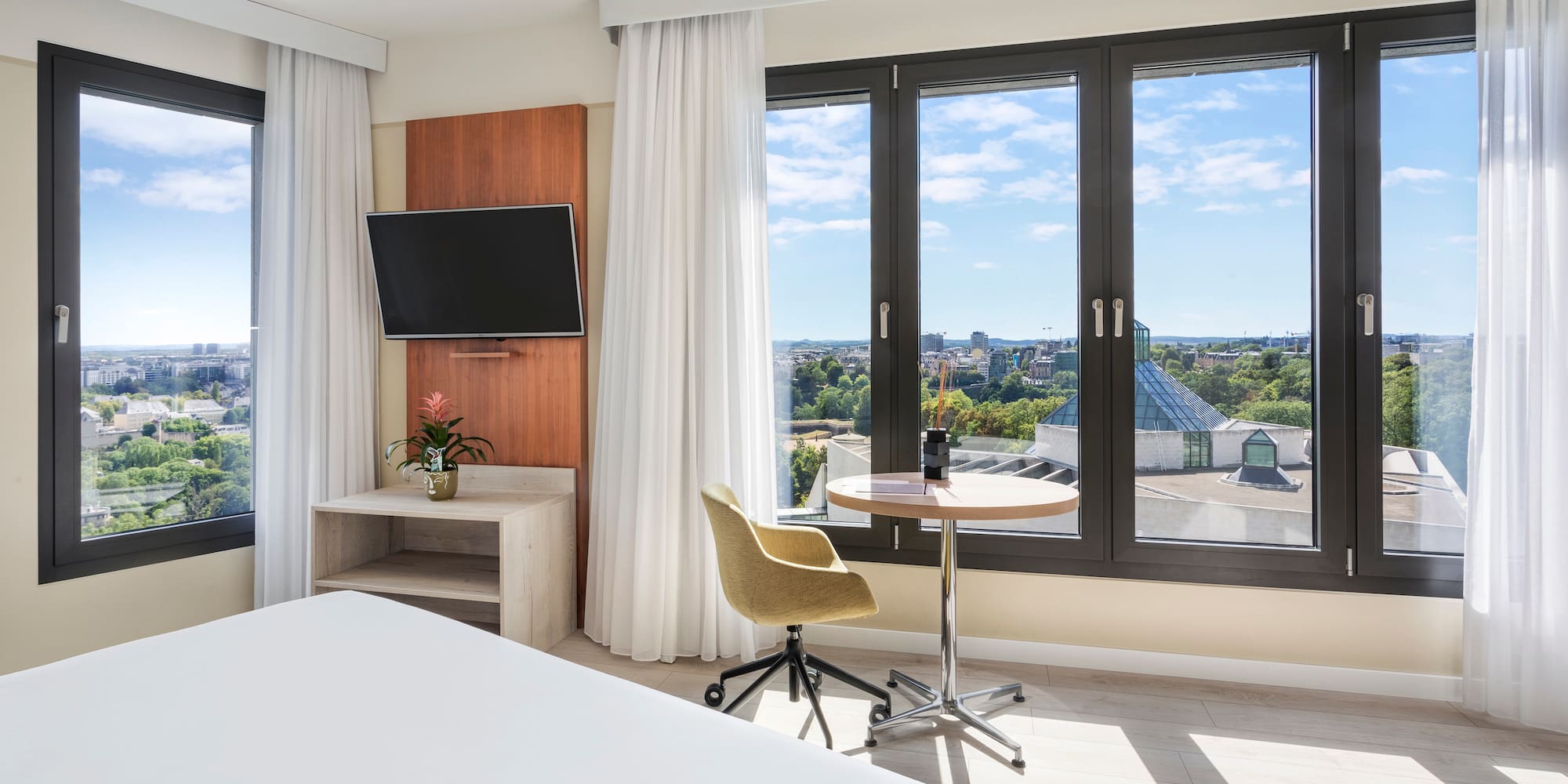 a room with a bed and a table and a television