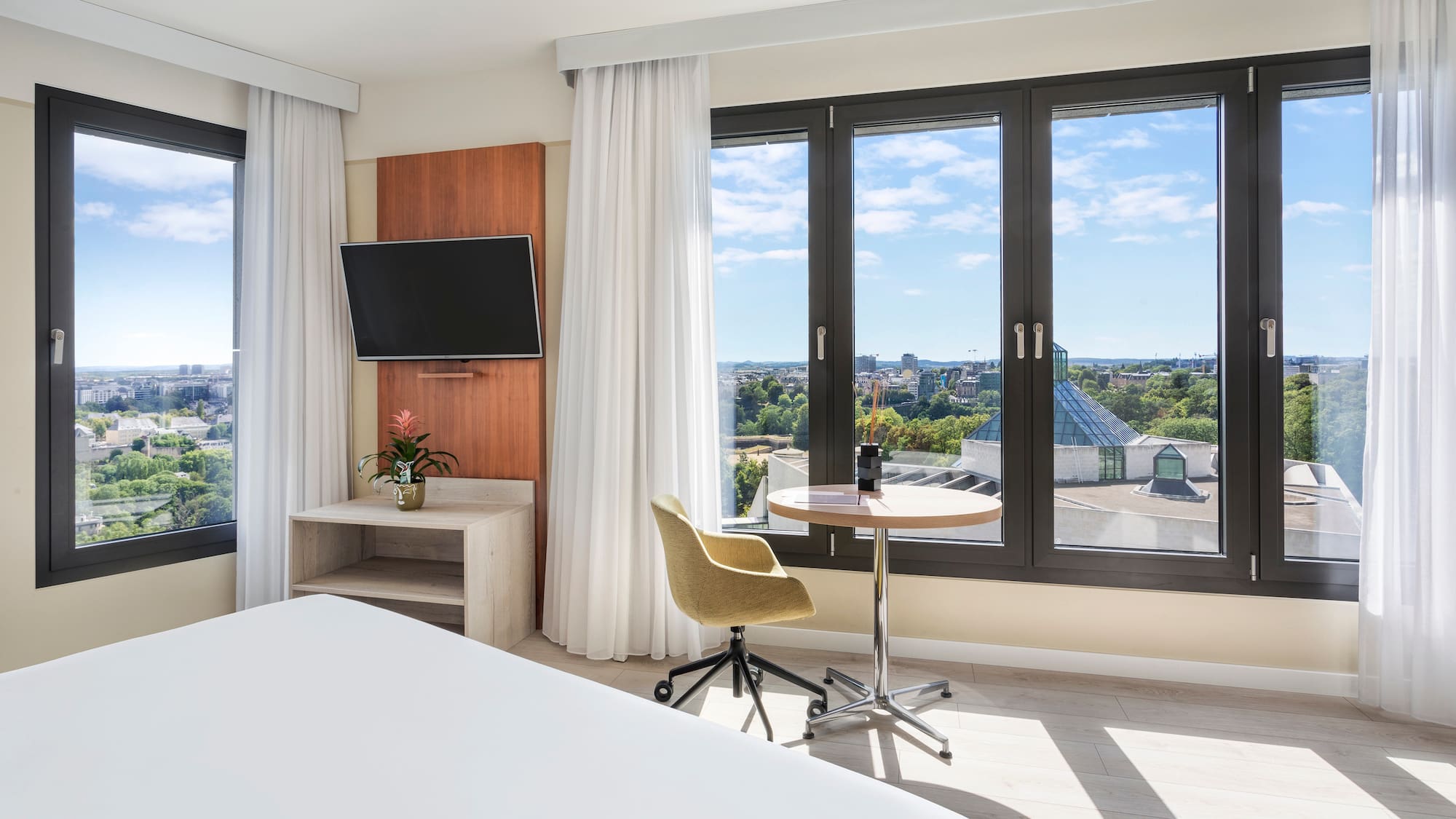 a room with a bed and a table and a television