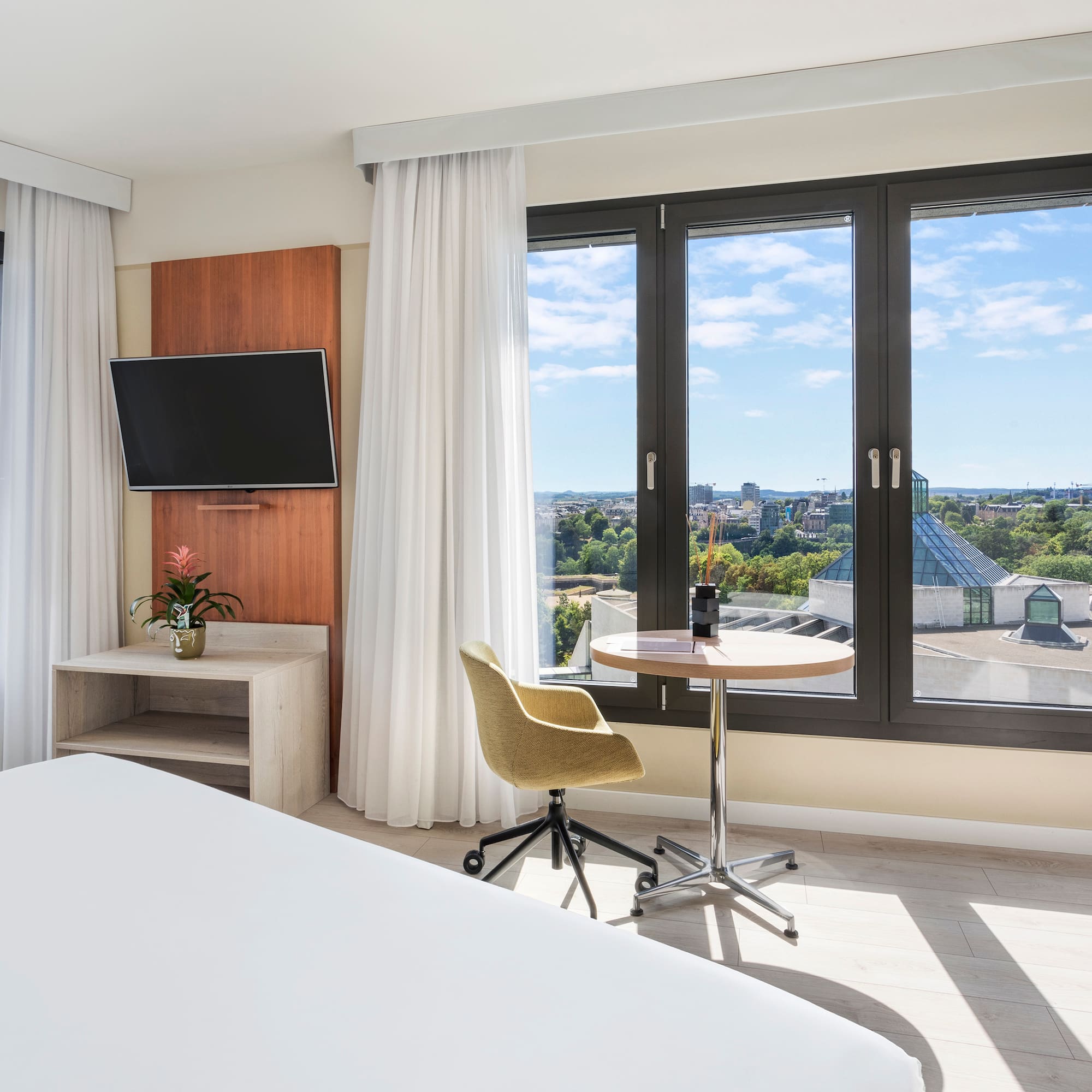 a room with a bed and a table and a television