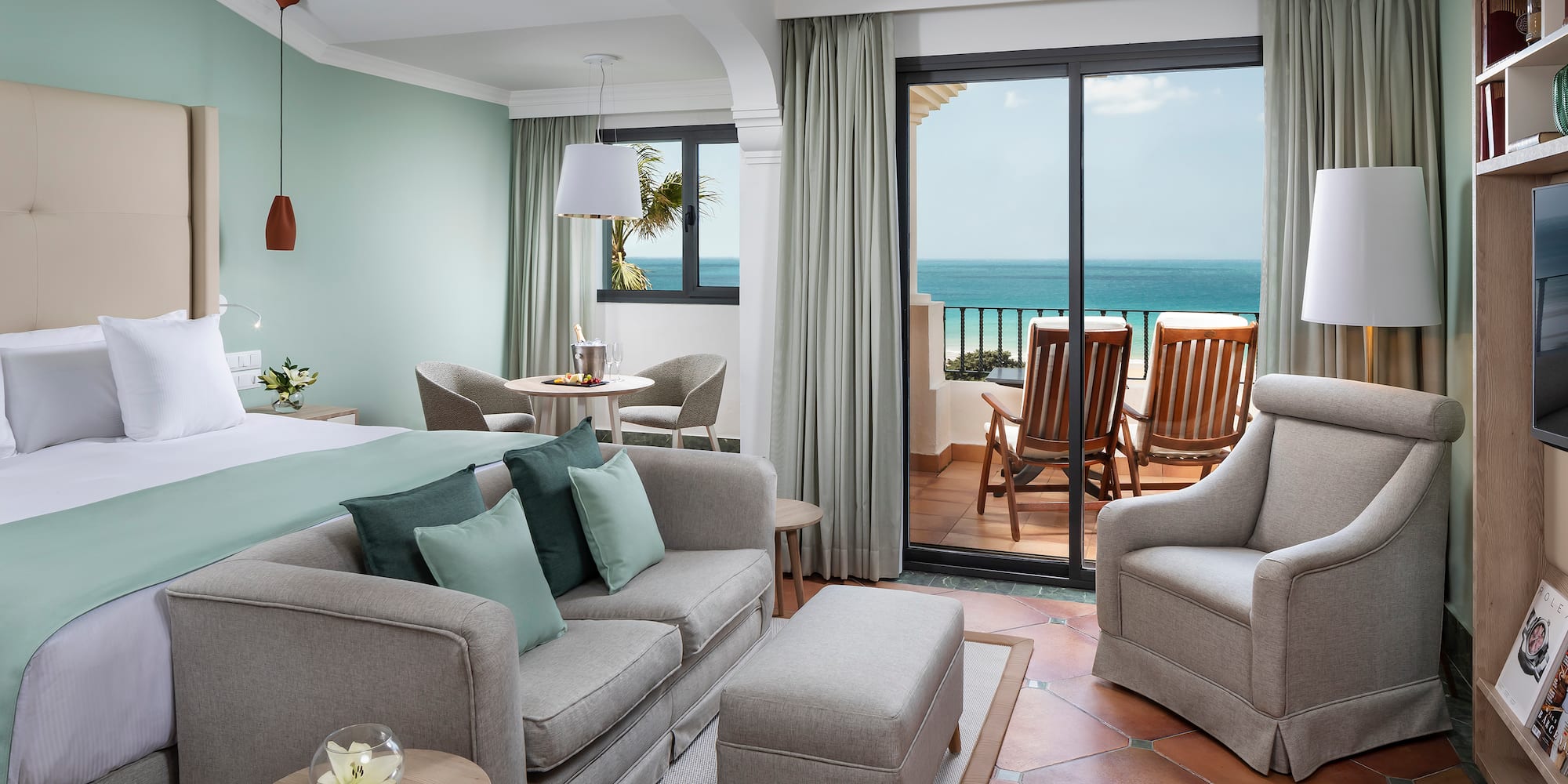 a room with a bed and chairs and a table