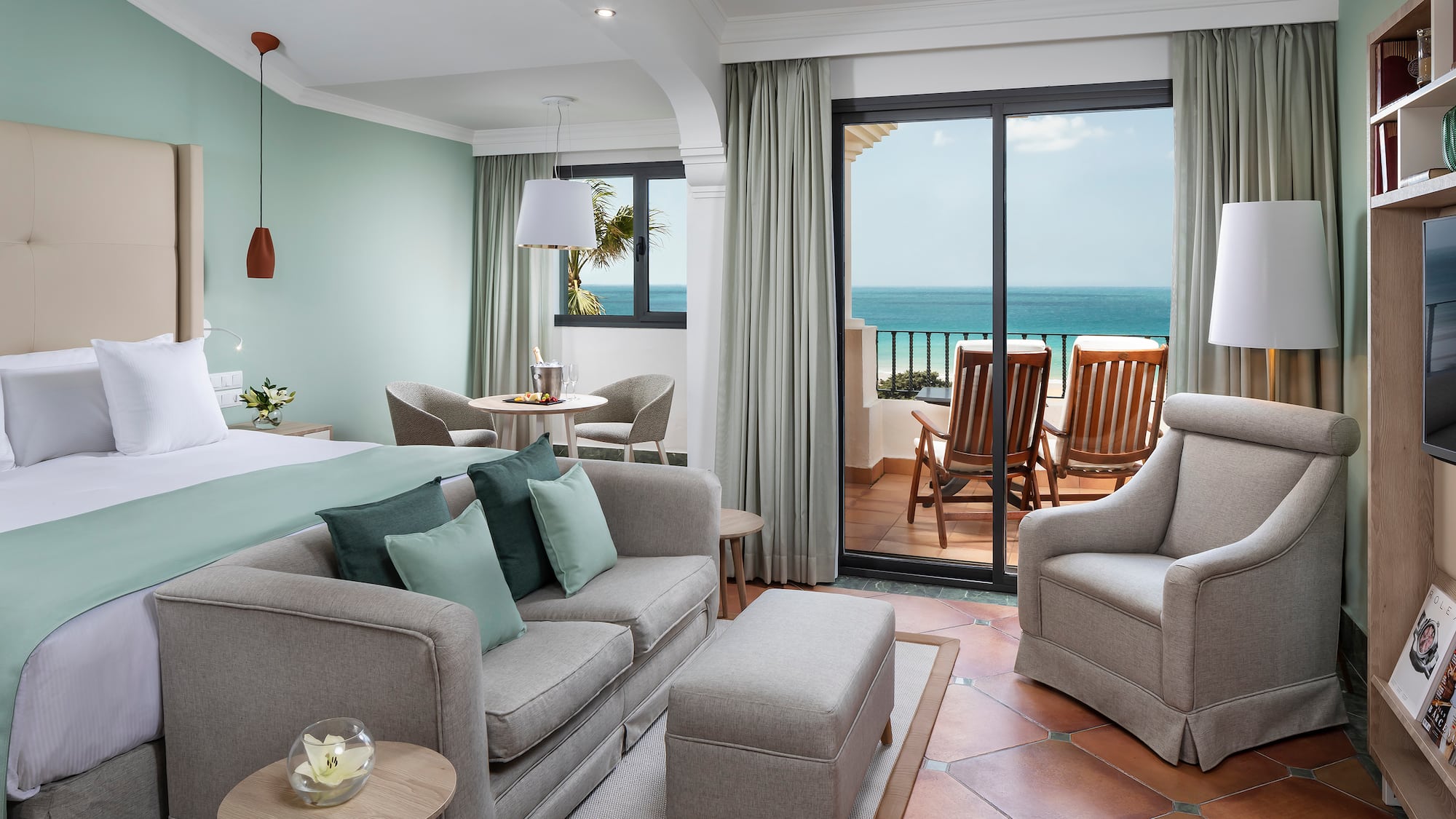 a room with a bed and chairs and a table