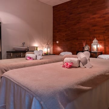 a massage room with towels and towels on the bed