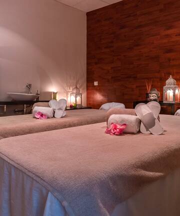 a massage room with towels and towels on the bed