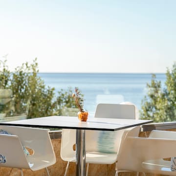 a table and chairs with a view of the ocean