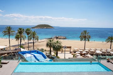 a pool with water slides and palm trees on a beach