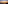Orange and blue sunset over ocean waves, dark beach, and distant city coastline.