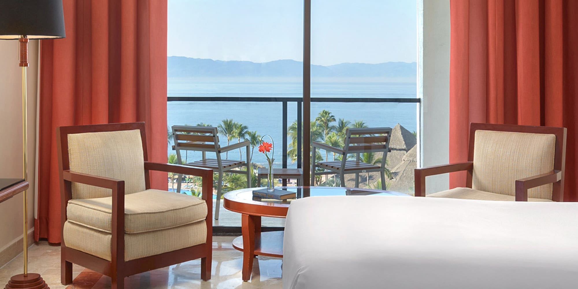 a room with a view of the ocean and a balcony