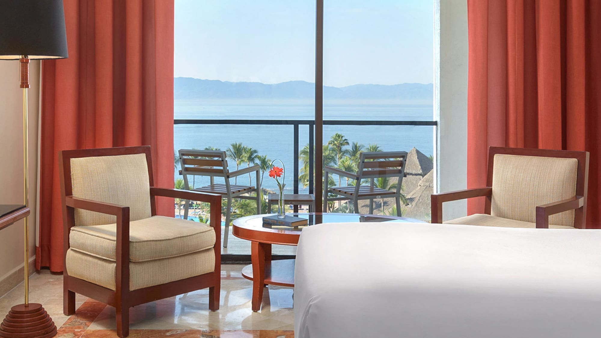 a room with a view of the ocean and a balcony