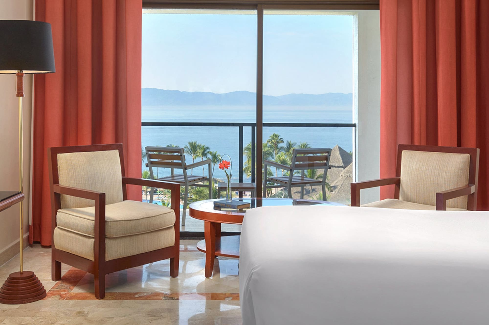 a room with a view of the ocean and a balcony