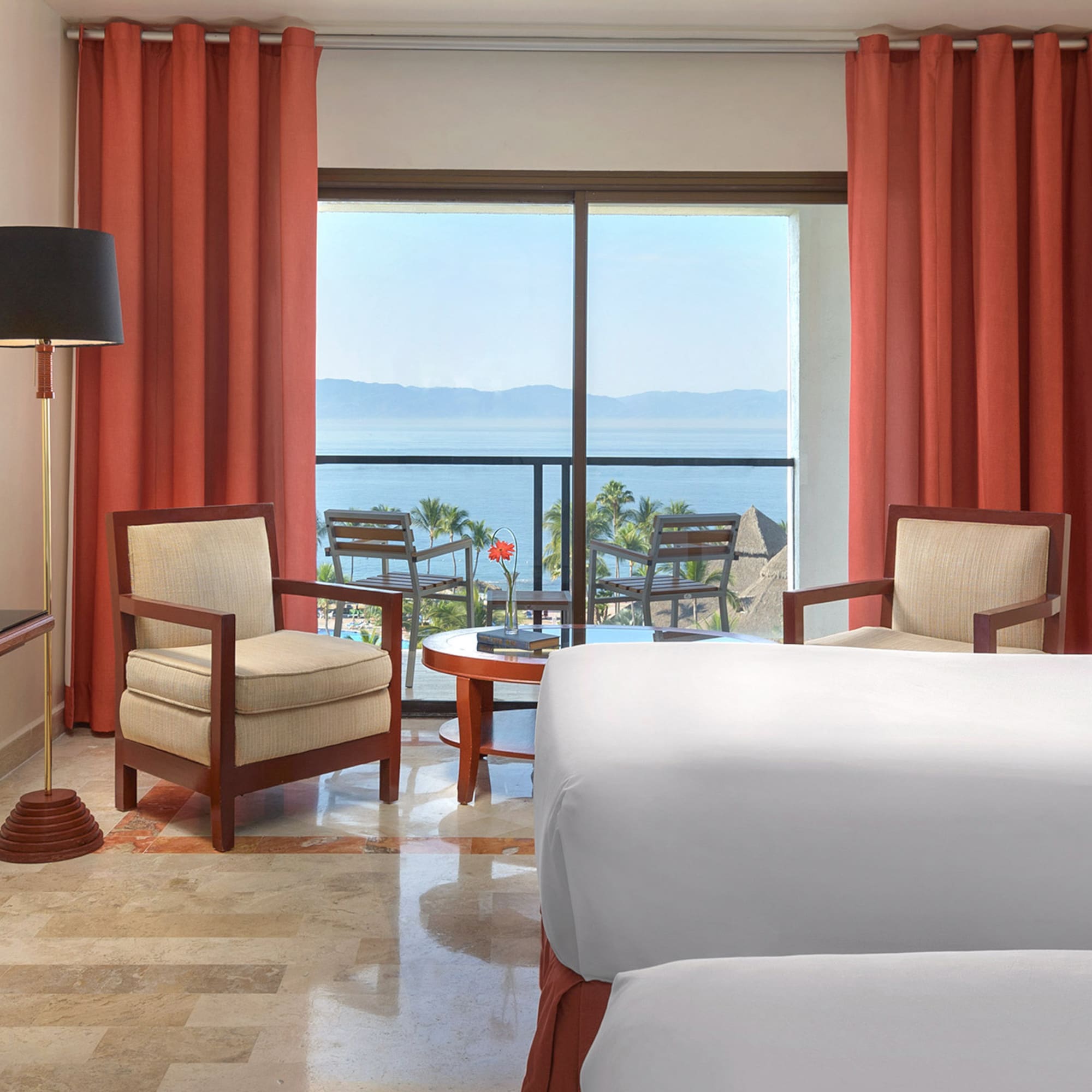 a room with a view of the ocean and a balcony