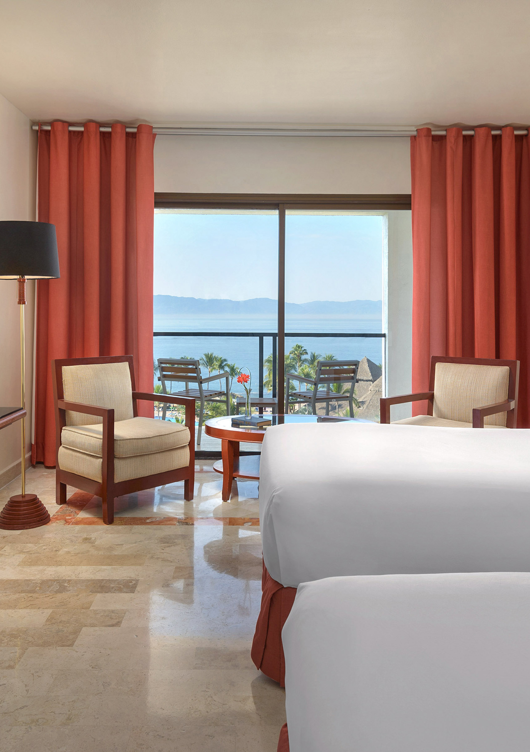 a room with a view of the ocean and a balcony