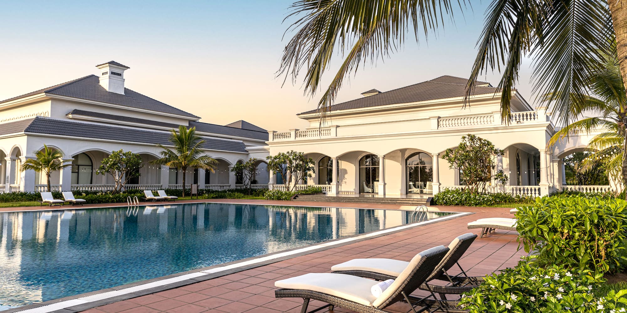 a pool with lounge chairs and palm trees