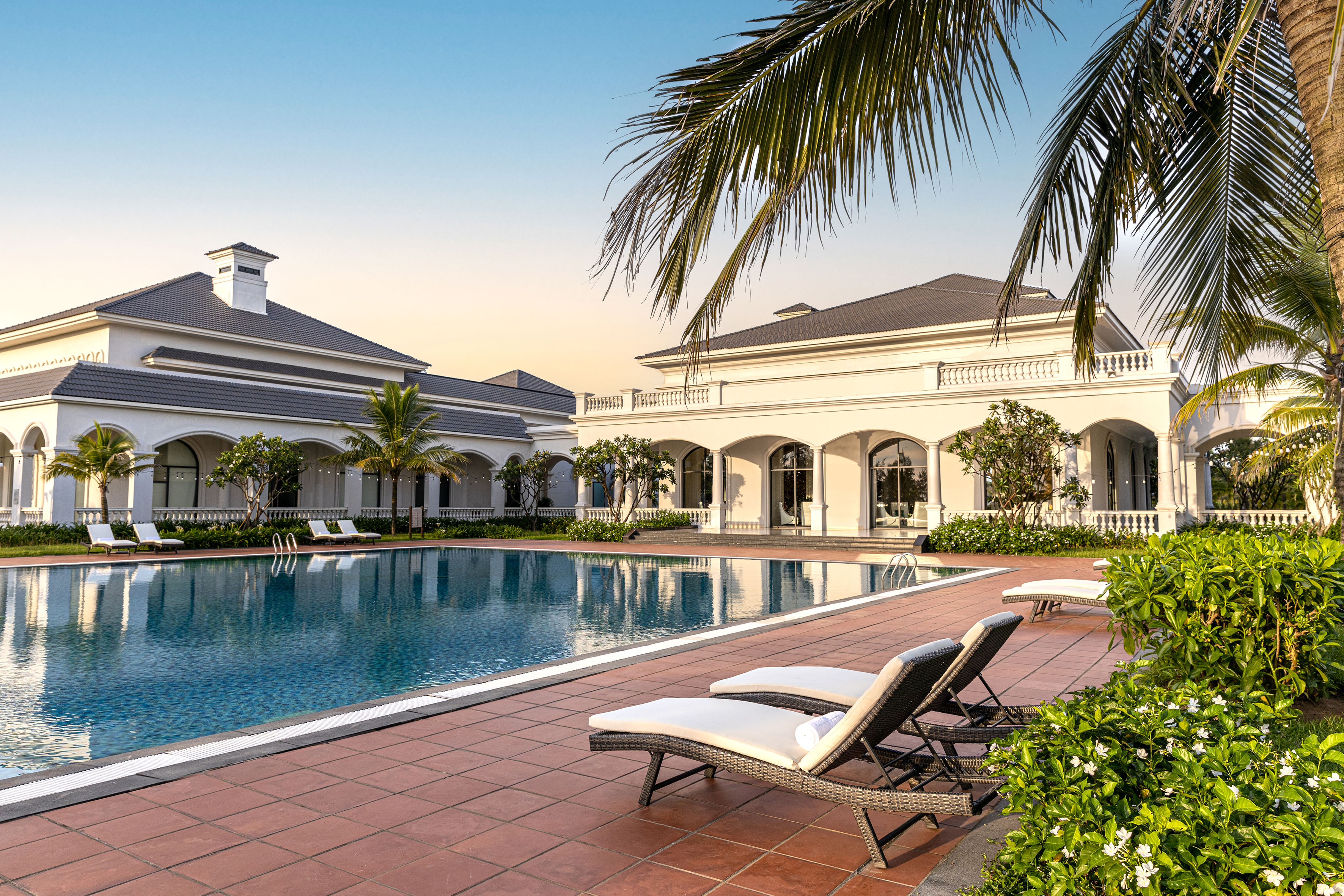 a pool with lounge chairs and palm trees