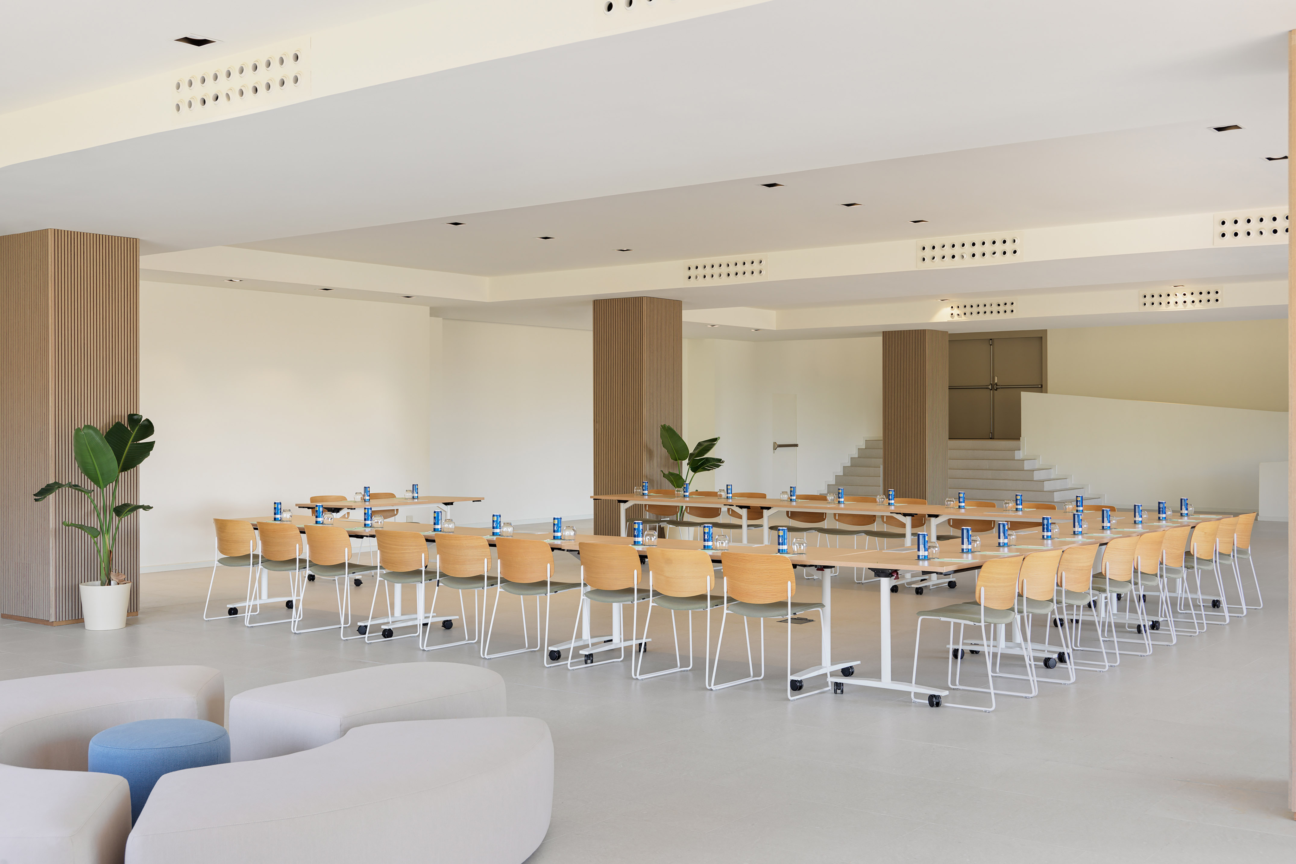 Modern conference room with U-shaped tables, chairs, and lounge seating.