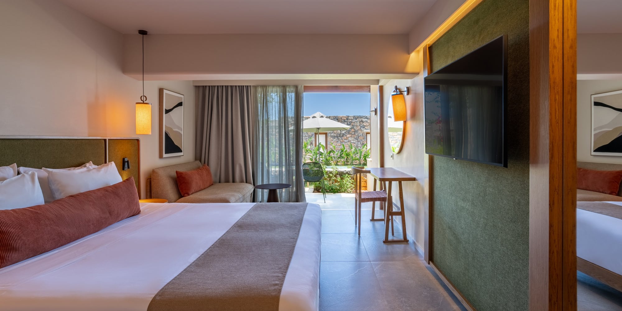 Modern luxury hotel room with king bed, sofa, TV, and private outdoor terrace.