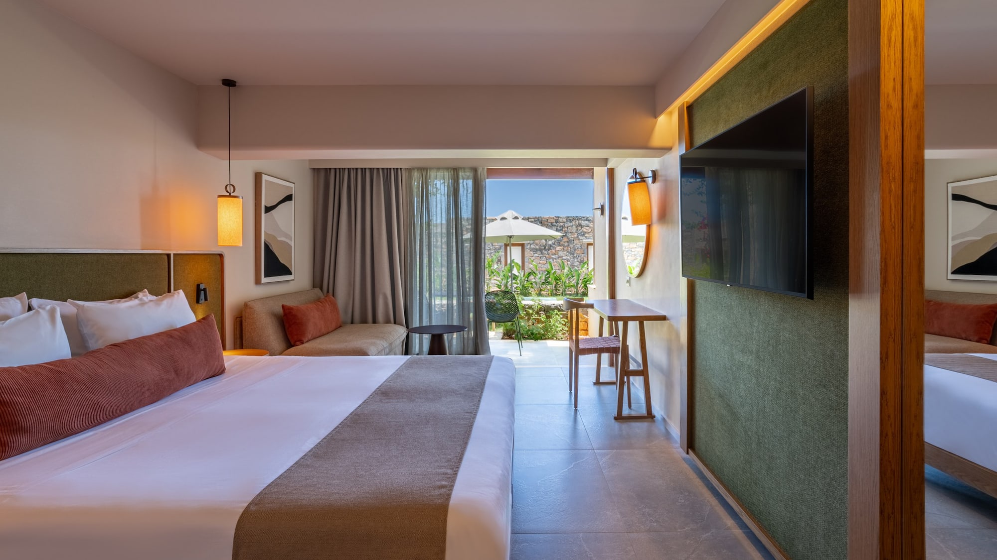 Modern luxury hotel room with king bed, sofa, TV, and private outdoor terrace.