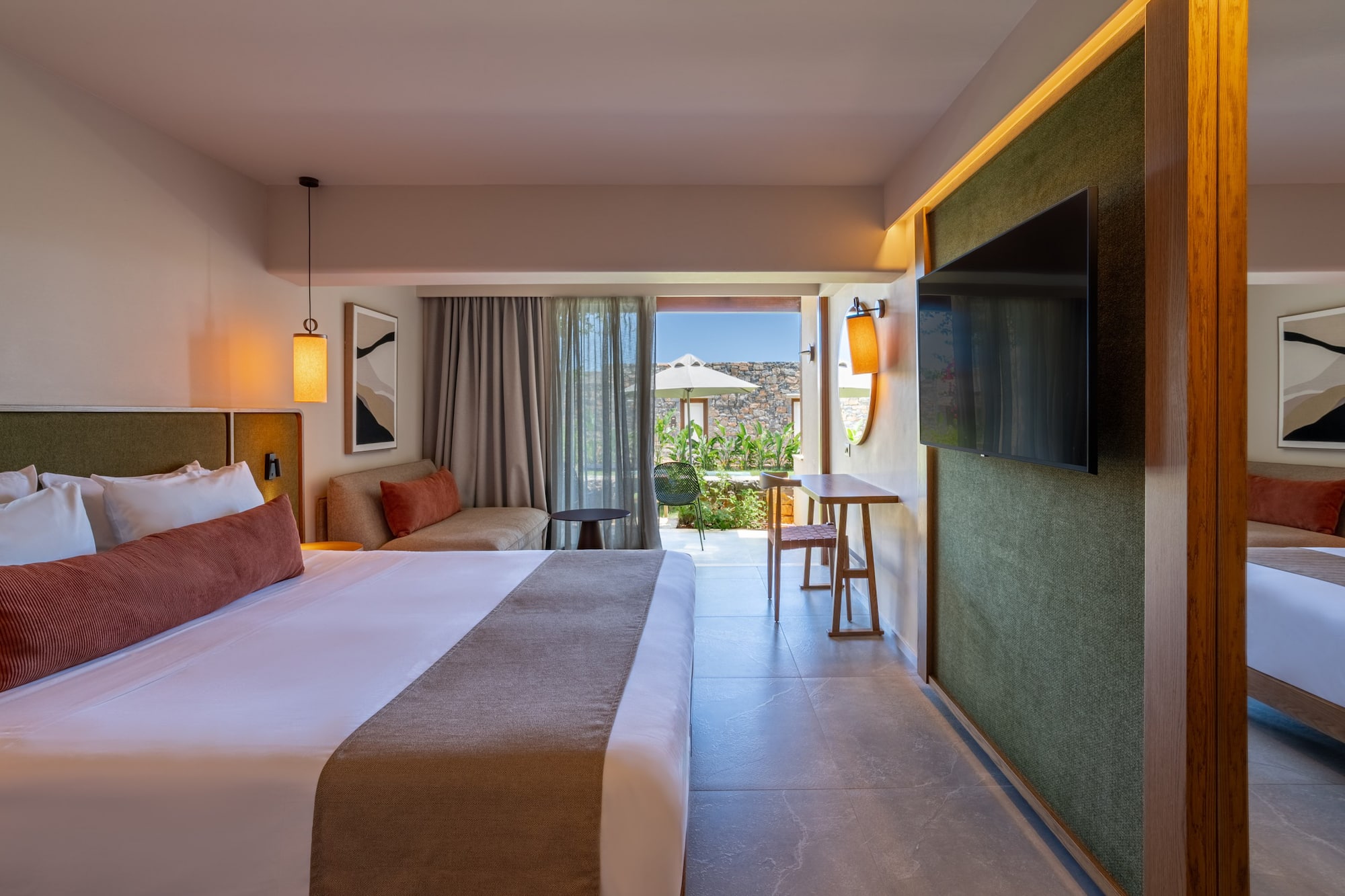 Modern luxury hotel room with king bed, sofa, TV, and private outdoor terrace.