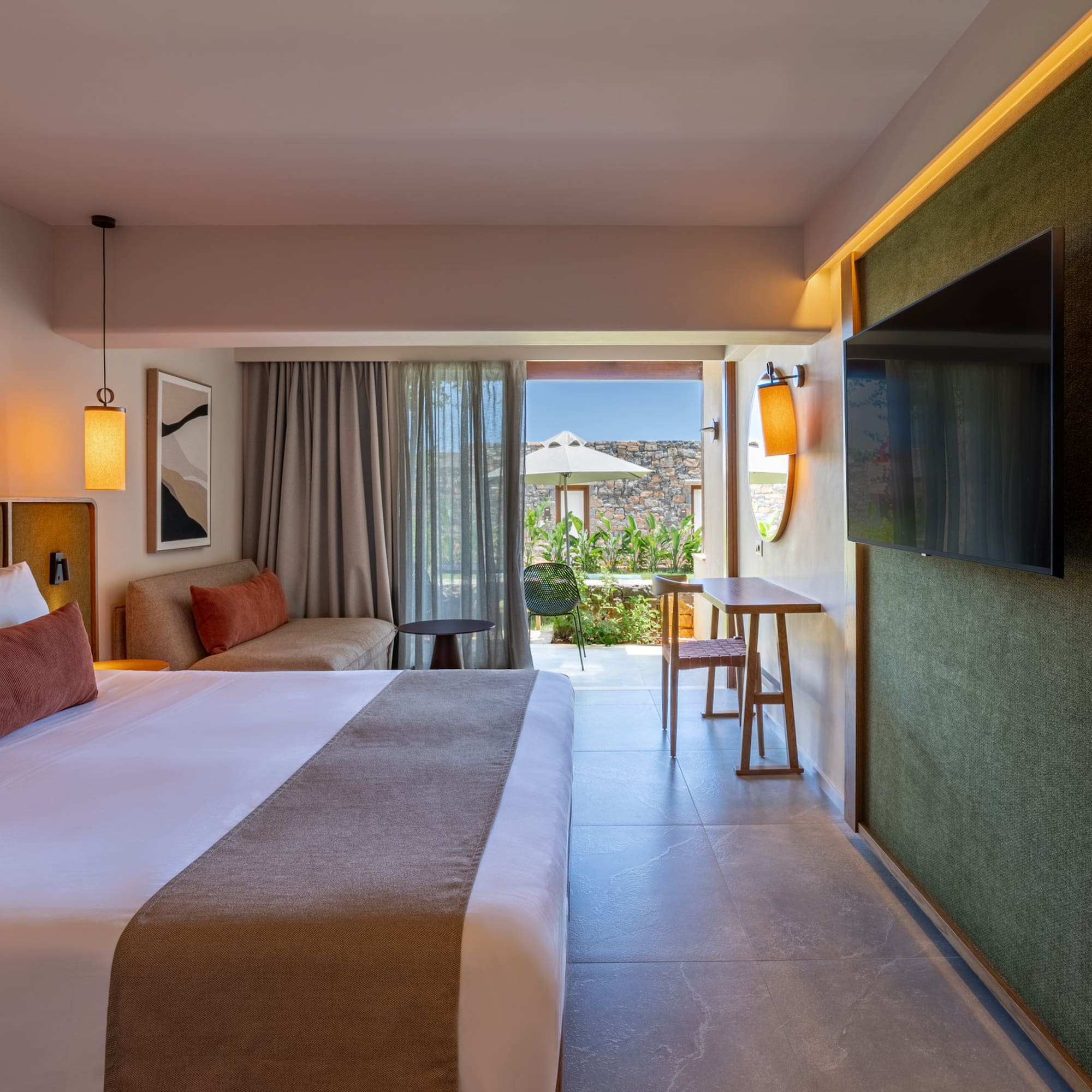 Modern luxury hotel room with king bed, sofa, TV, and private outdoor terrace.
