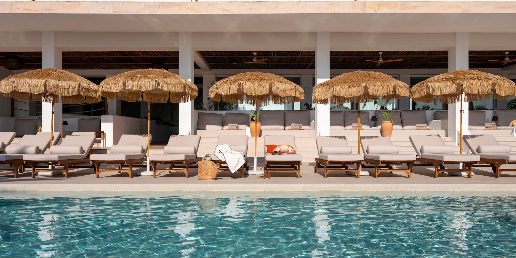 a pool with umbrellas and lounge chairs
