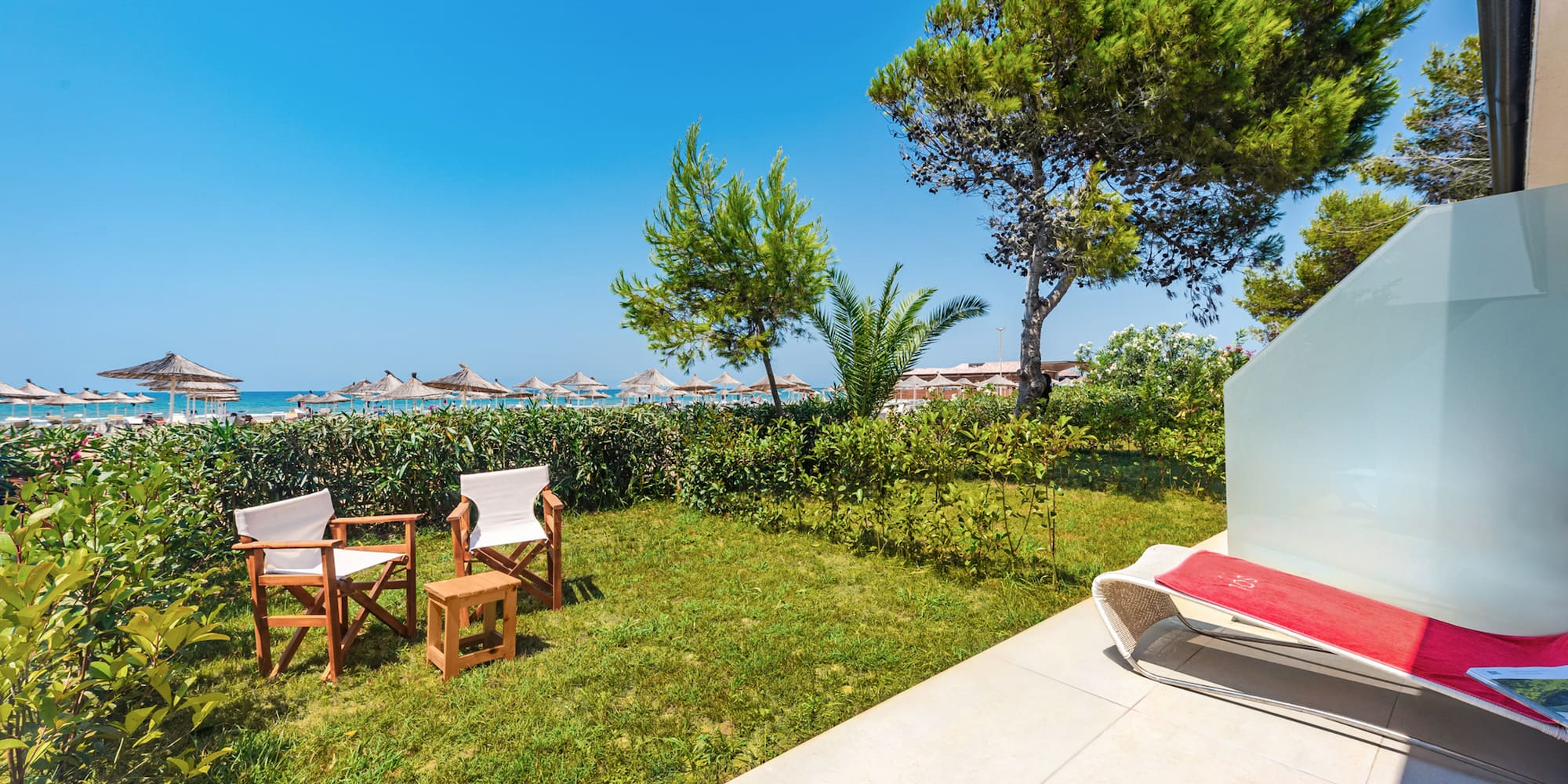 a lawn chair and chairs on a patio by a beach