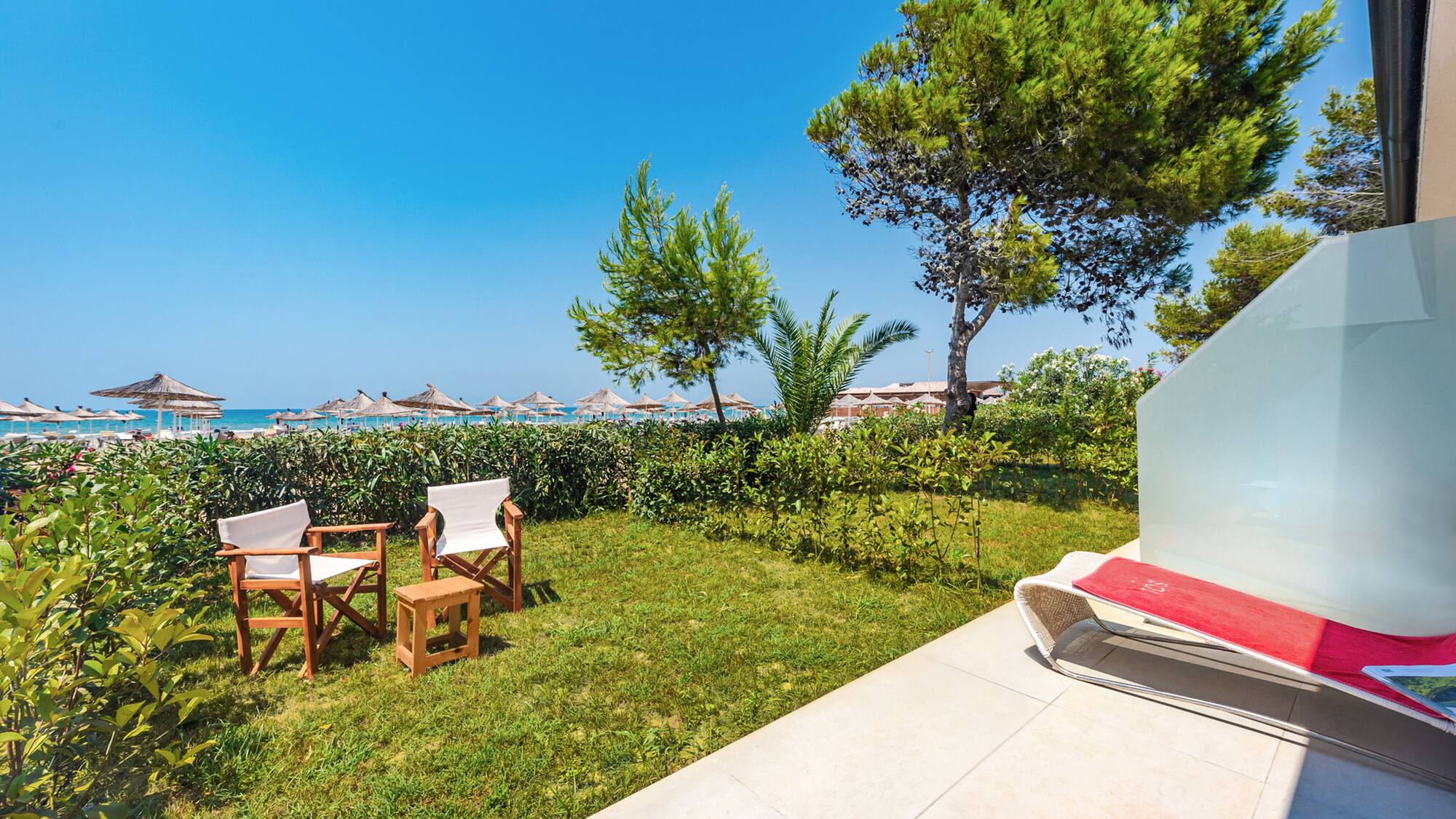 a lawn chair and chairs on a patio by a beach