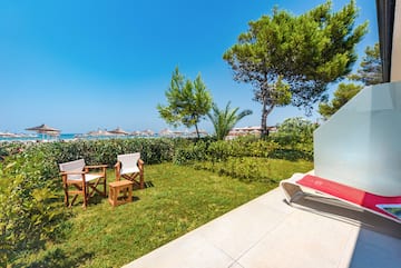 a lawn chair and chairs on a patio by a beach