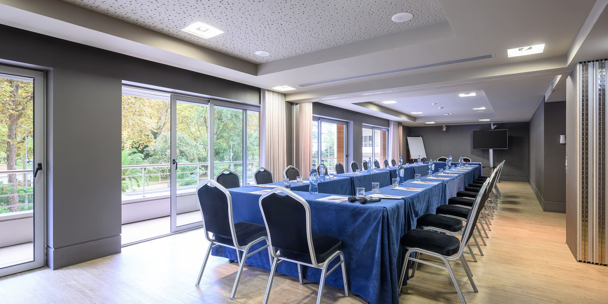 a long conference room with a blue table cloth and chairs