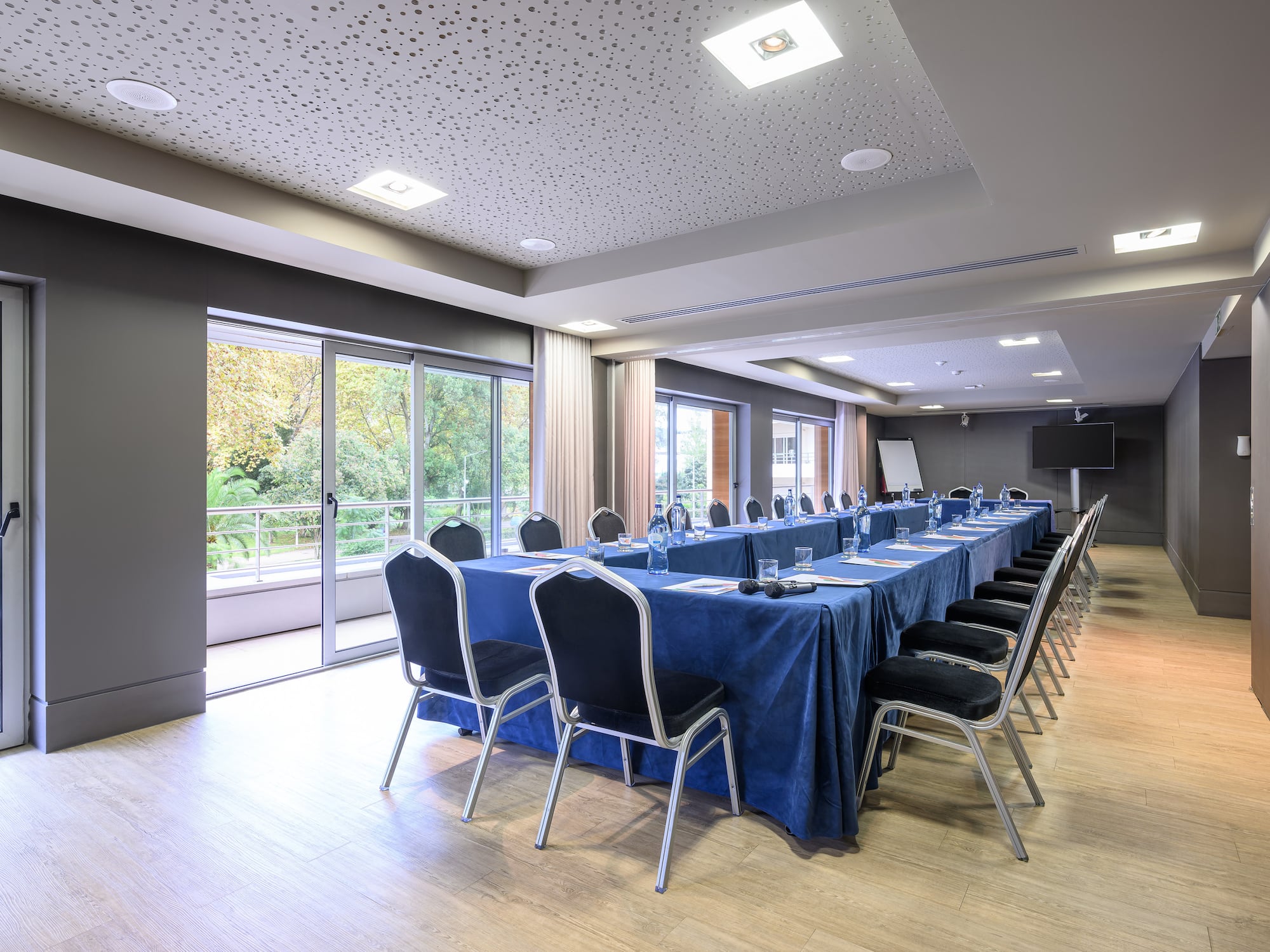 a long conference room with a blue table cloth and chairs