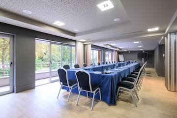 a long conference room with a blue table cloth and chairs