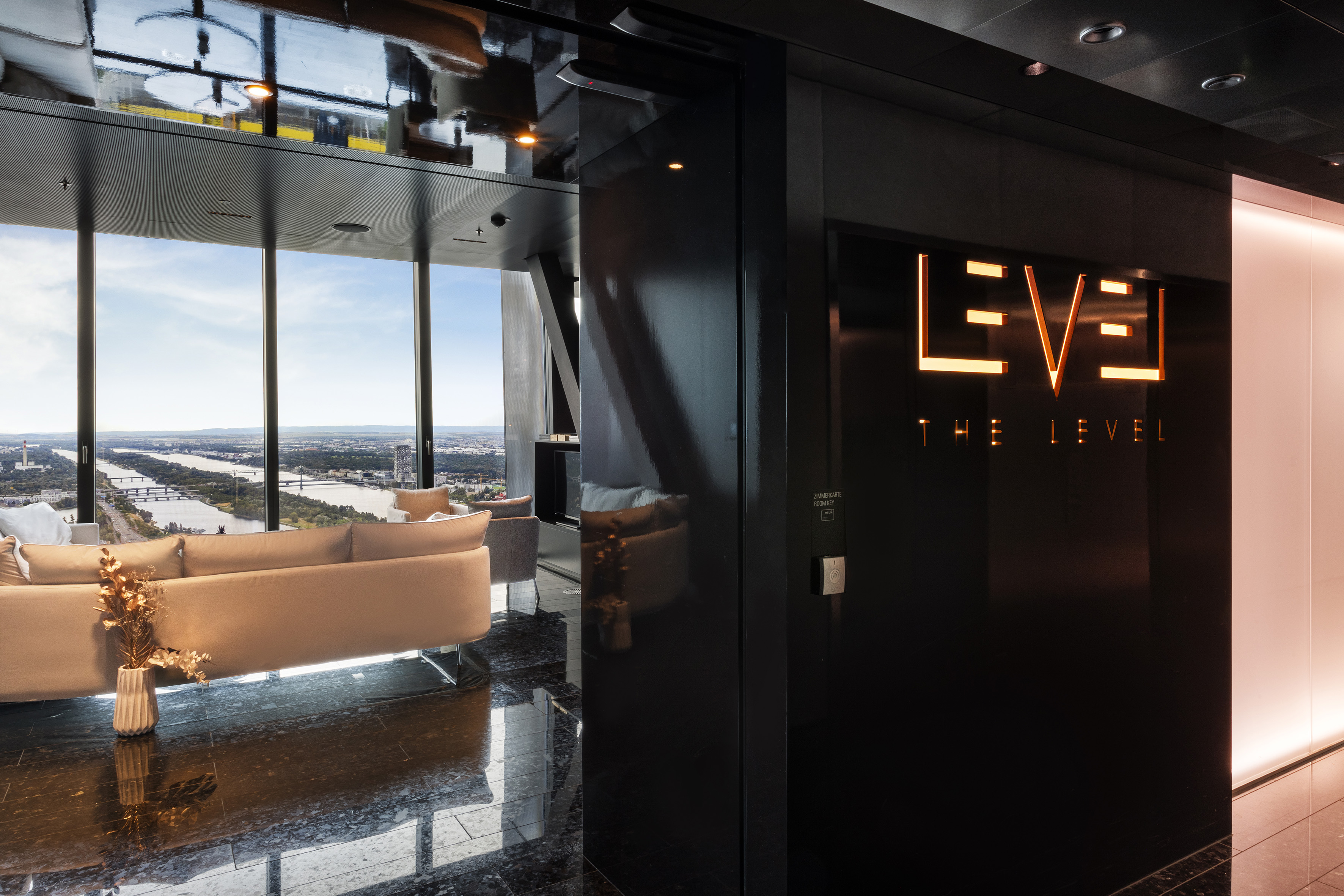 Luxury high-rise lounge with city view and 'THE LEVEL' illuminated sign.