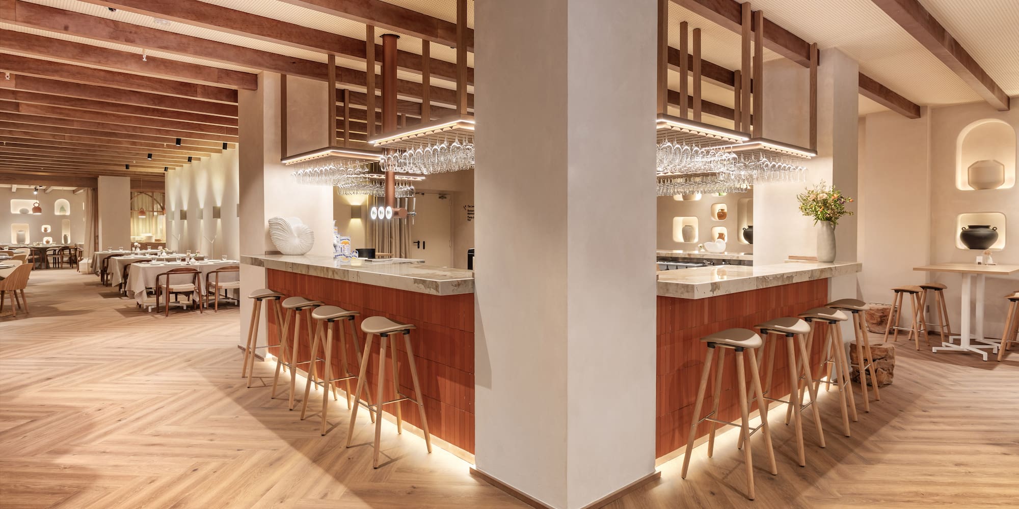 a bar with stools and chandeliers