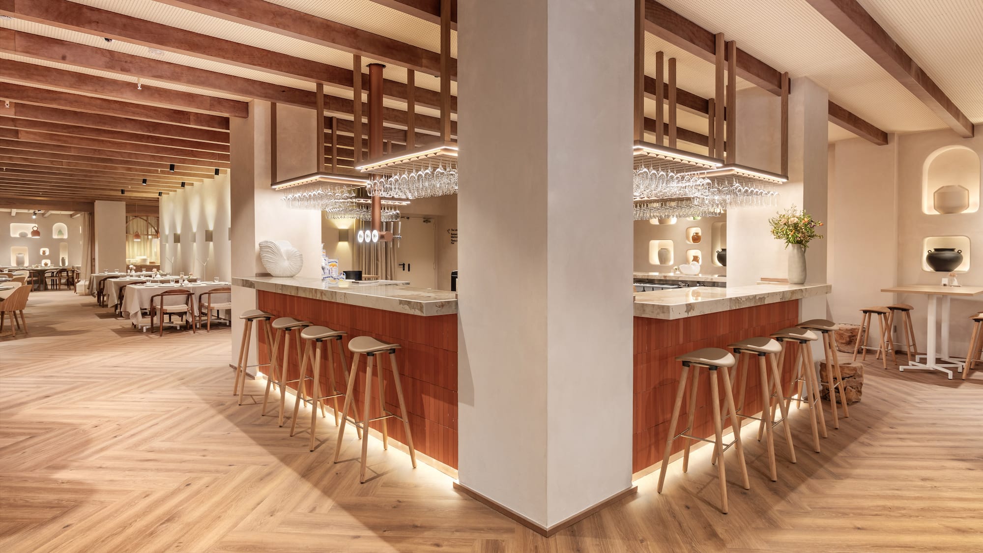a bar with stools and chandeliers