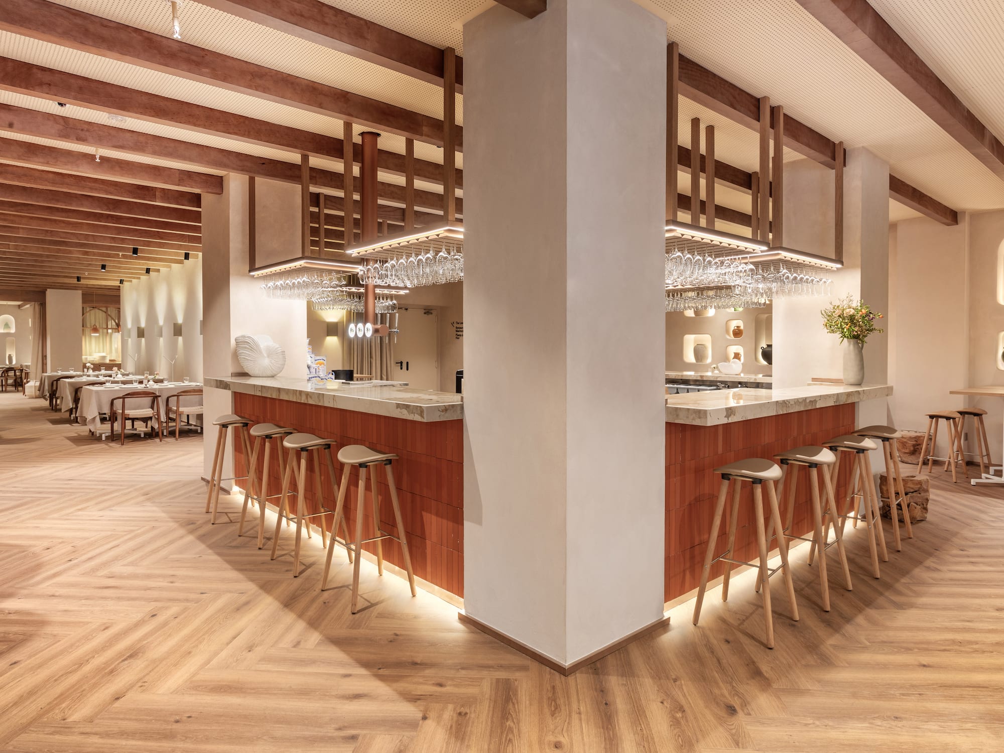 a bar with stools and chandeliers