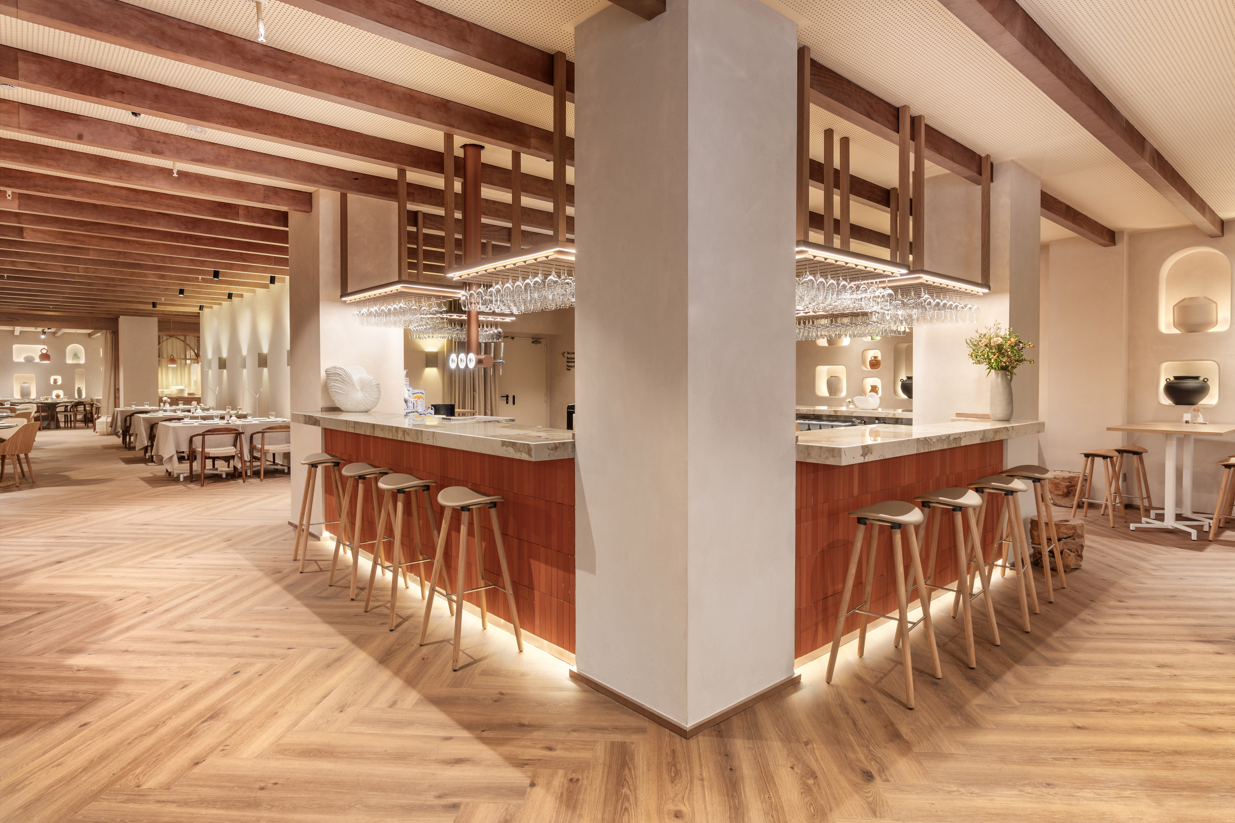 a bar with stools and chandeliers