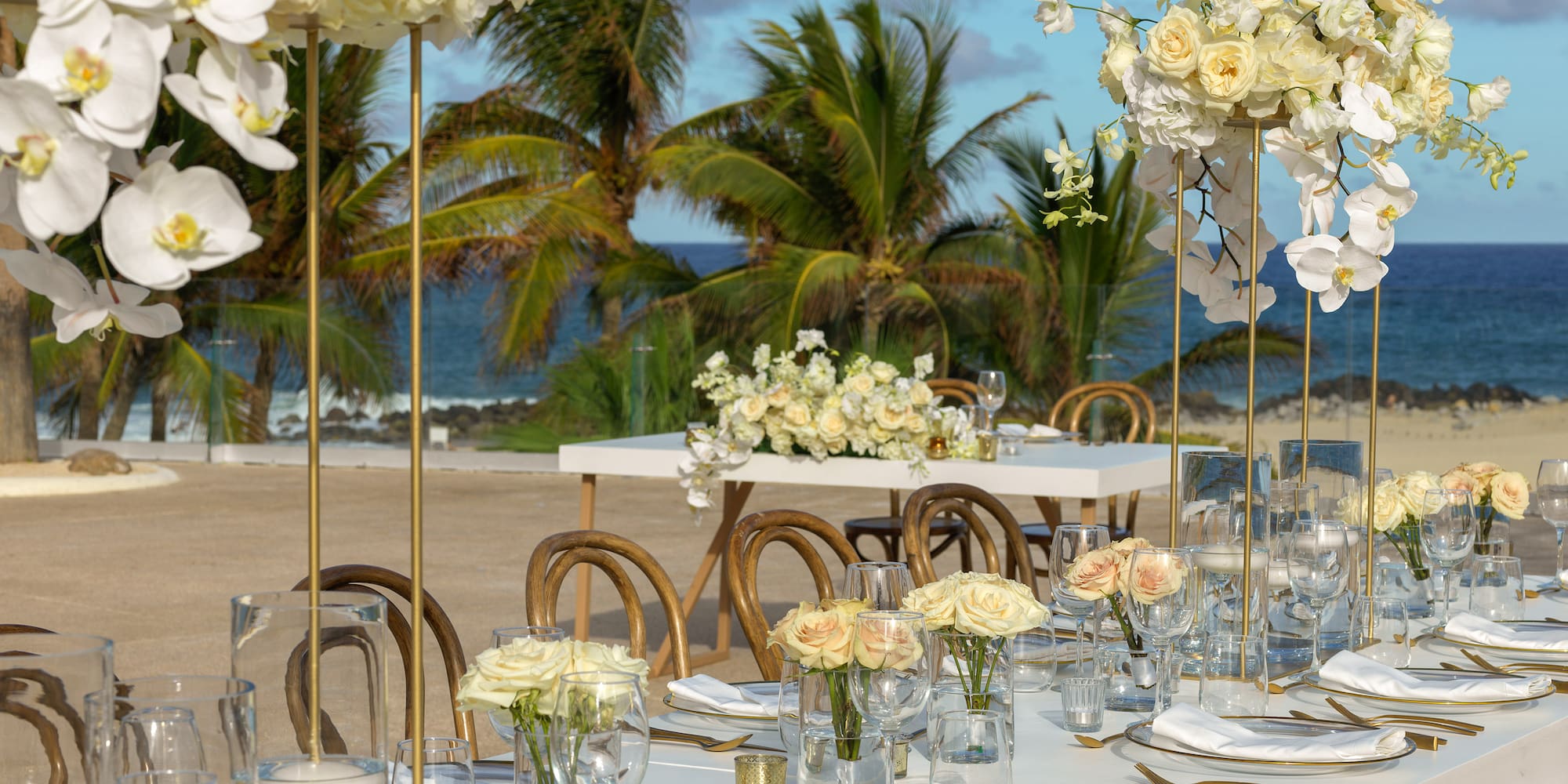 Beach wedding table with white flowers, gold accents, and ocean view. - Terraza Océano 2 - Paradisus Los Cabos - Adults Only, Los Cabos
