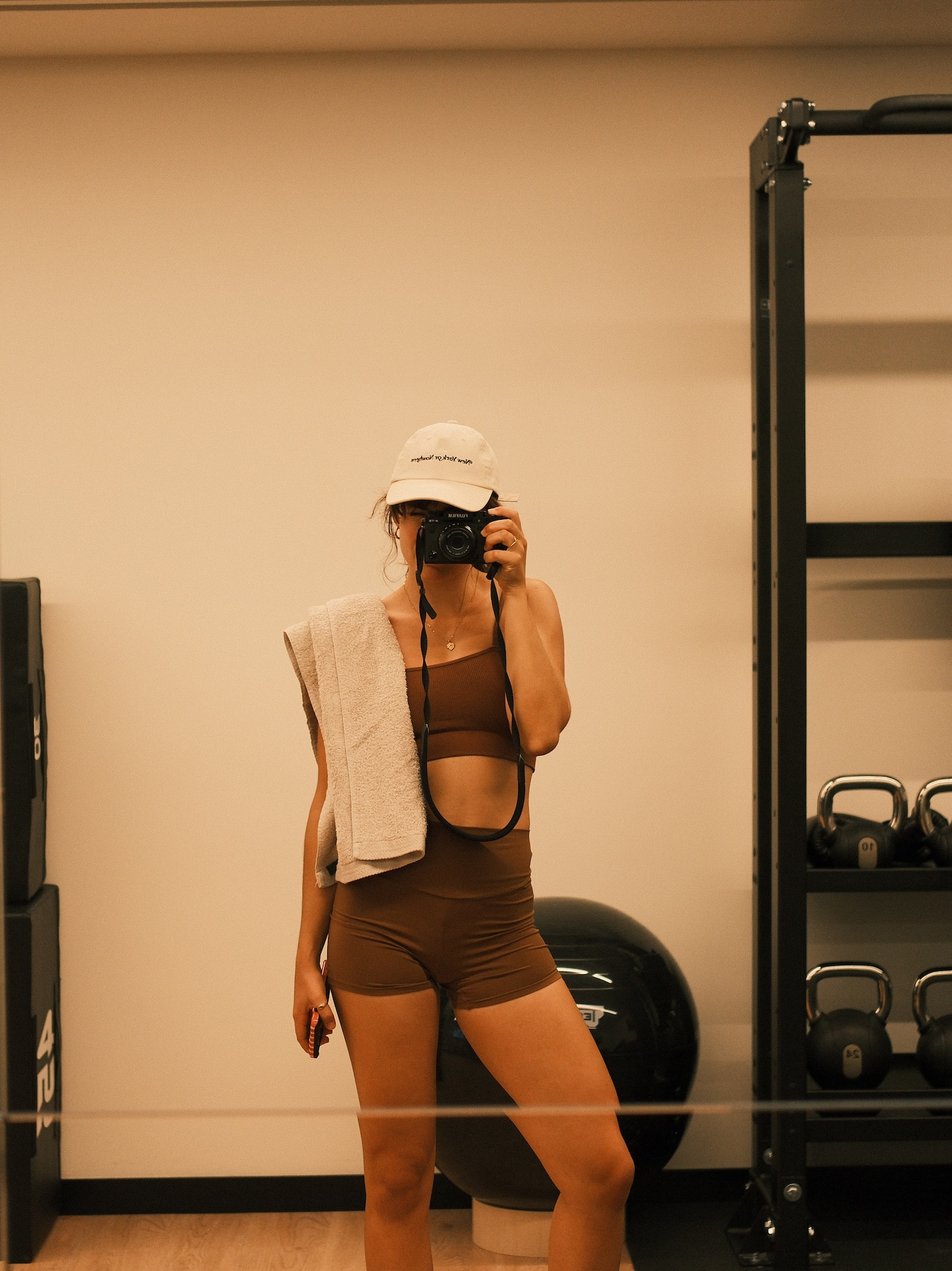 a woman taking a picture of herself in a gym