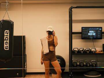 a woman taking a picture of herself in a gym