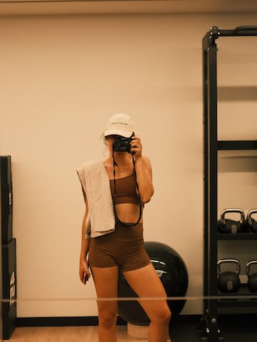 a woman taking a picture of herself in a gym