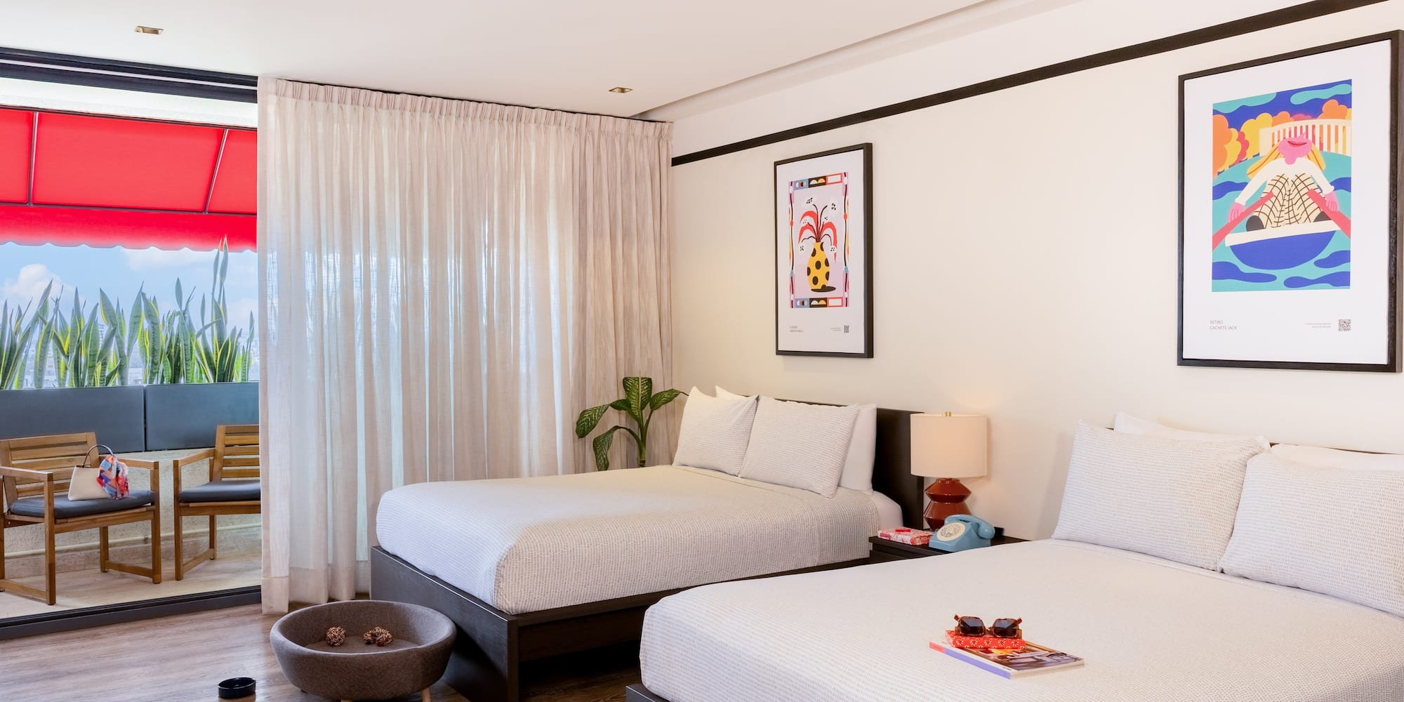 Pet-friendly hotel room with two beds, modern decor, artwork, and balcony.