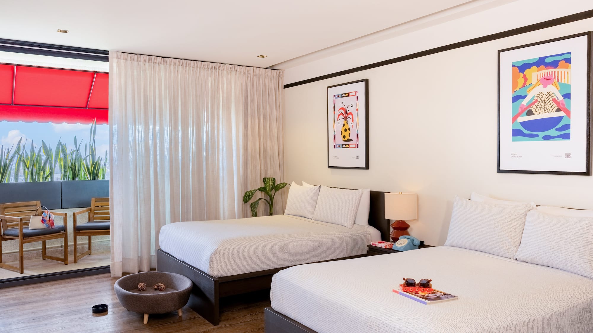 Pet-friendly hotel room with two beds, modern decor, artwork, and balcony.